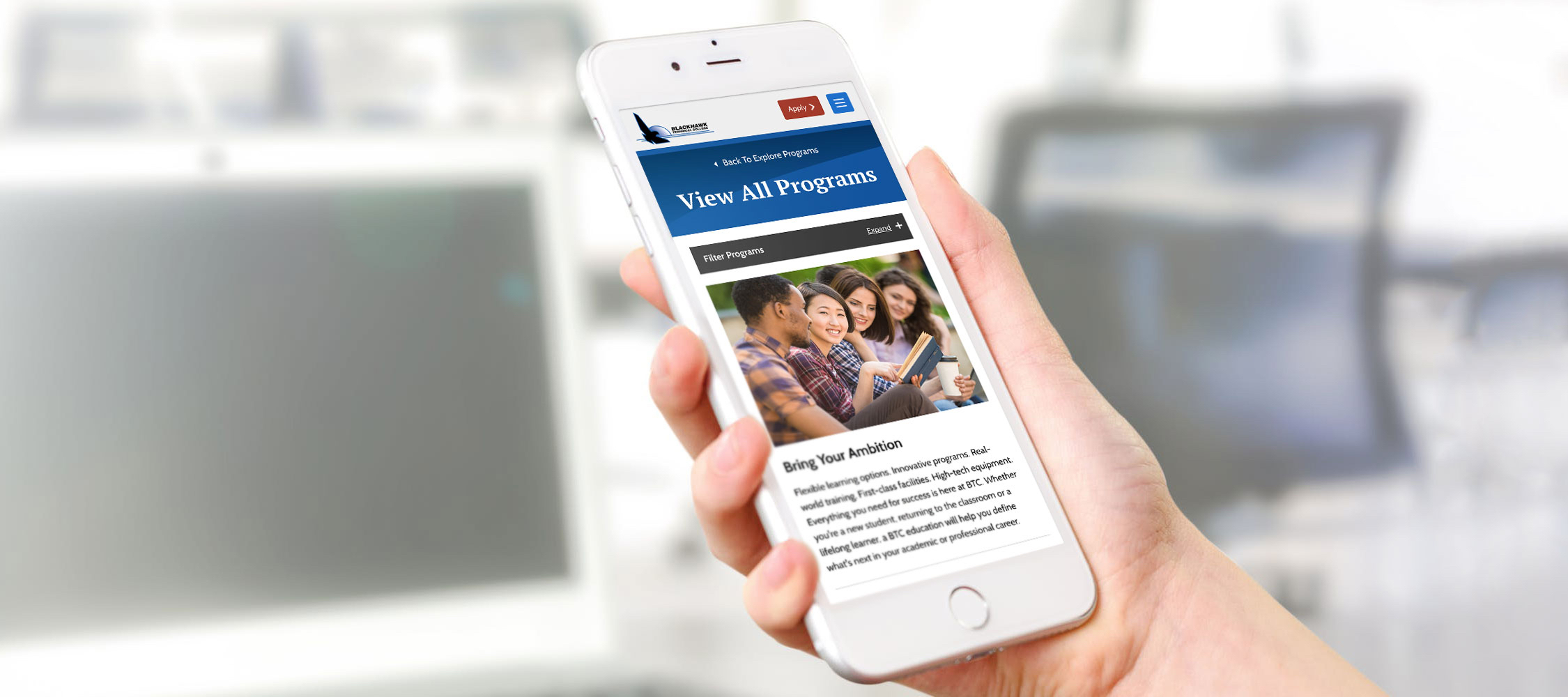 Hand holding mobile phone with Blackhawk Technical College website on screen